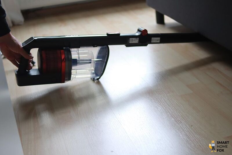 Man sieht den Shark Anti Hair Wrap Flexoloxy bei der Reinigung unter Möbeln.